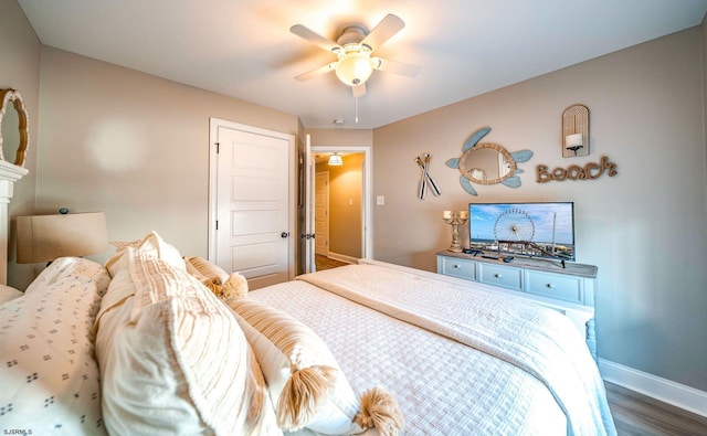 bedroom with dark wood-style flooring, a ceiling fan, and baseboards