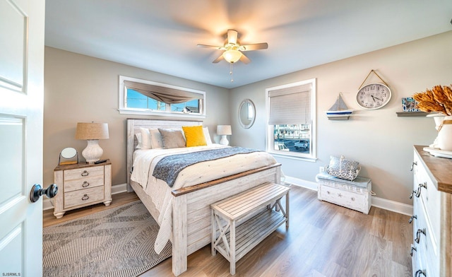 bedroom with light wood-style floors, baseboards, and a ceiling fan