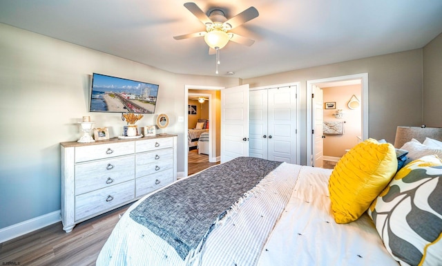 bedroom with wood finished floors, a ceiling fan, baseboards, a closet, and ensuite bath