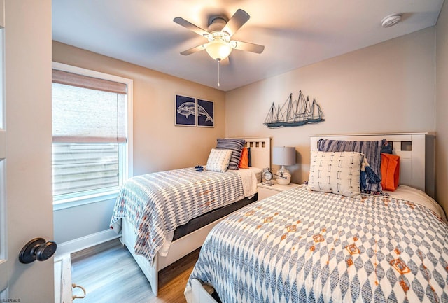 bedroom featuring ceiling fan, wood finished floors, and baseboards