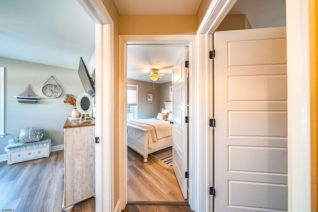 hallway featuring baseboards and wood finished floors