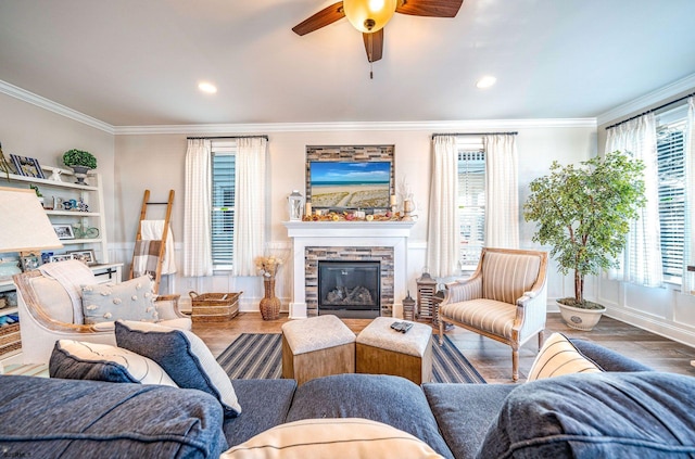 living room with ceiling fan, ornamental molding, wood finished floors, a fireplace, and recessed lighting