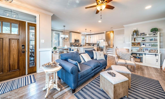 living room featuring ornamental molding, wood finished floors, and a ceiling fan