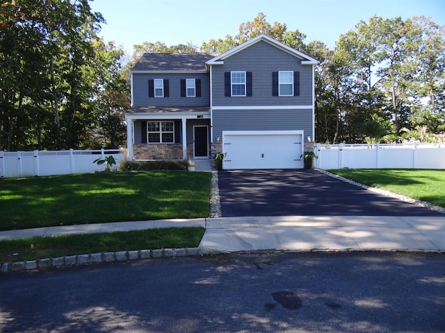 view of front facade with aphalt driveway, a front yard, stone siding, and fence