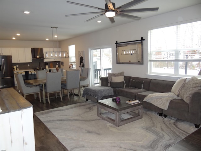 living area featuring a ceiling fan, recessed lighting, and dark wood finished floors