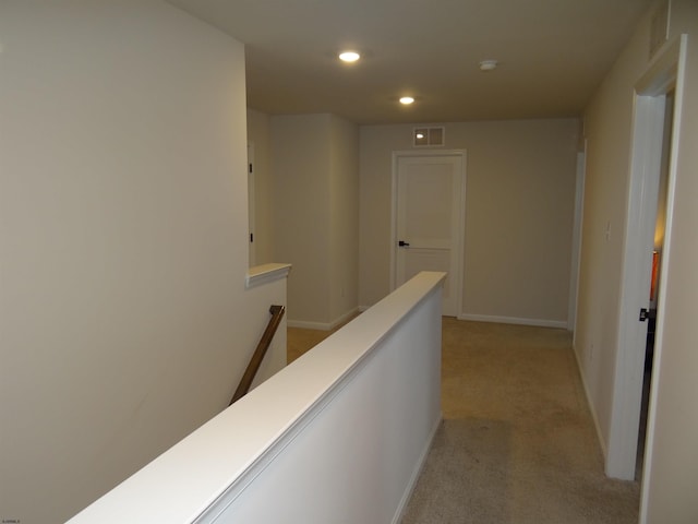 corridor with recessed lighting, light colored carpet, visible vents, an upstairs landing, and baseboards