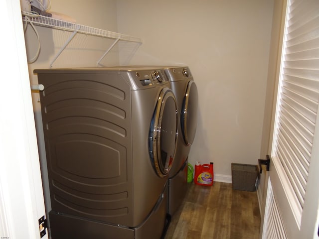 laundry room featuring laundry area, separate washer and dryer, wood finished floors, and baseboards