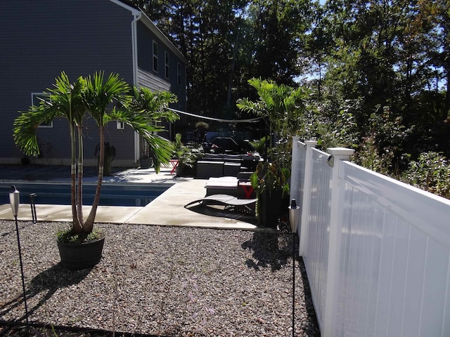 view of yard with a patio area, fence, and an outdoor pool