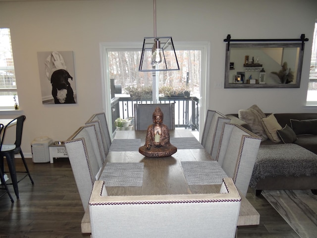 dining space with dark wood finished floors and a notable chandelier