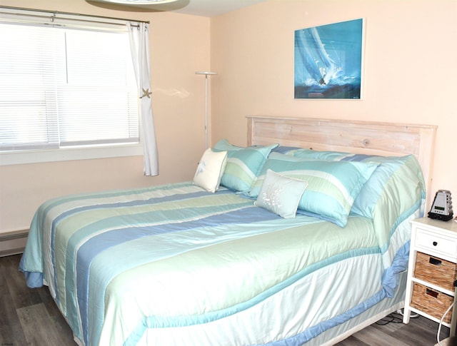 bedroom featuring baseboard heating and wood finished floors