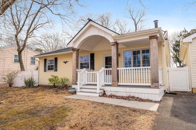 view of front of property featuring a porch, a gate, and fence