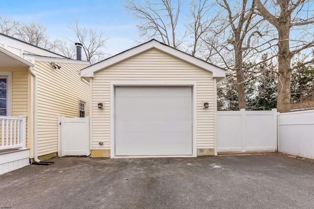 garage featuring fence and driveway