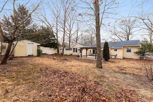 view of yard featuring a patio, fence, an outdoor structure, and a storage shed