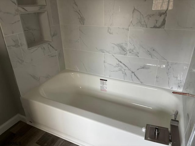 full bath featuring wood finished floors and a tub