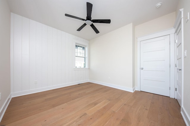 spare room featuring light wood-type flooring, baseboards, and a ceiling fan