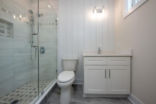 full bathroom with a stall shower, vanity, toilet, and baseboards