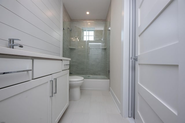 bathroom with recessed lighting, shower / bath combination with glass door, vanity, and toilet