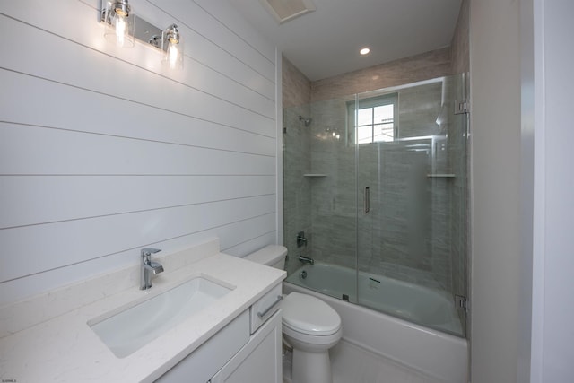 full bathroom with visible vents, shower / bath combination with glass door, vanity, and toilet