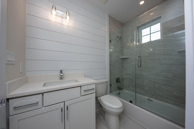 bathroom featuring combined bath / shower with glass door, vanity, and toilet