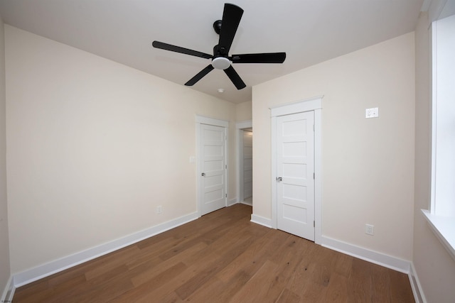 unfurnished bedroom featuring ceiling fan, wood finished floors, and baseboards