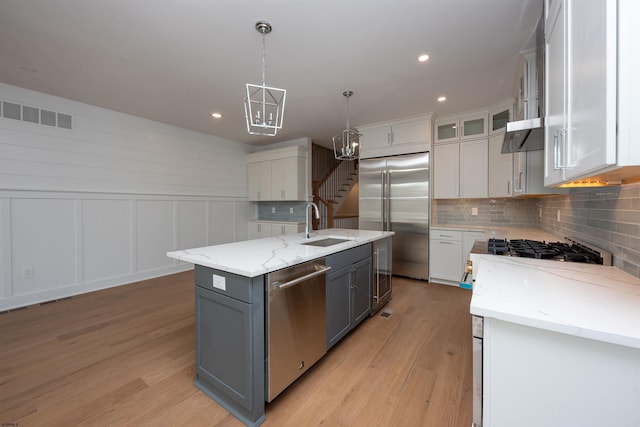 kitchen featuring stainless steel appliances, visible vents, light wood finished floors, and gray cabinetry