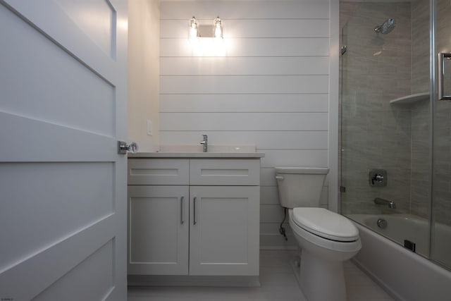 full bath featuring combined bath / shower with glass door, vanity, toilet, and tile patterned floors