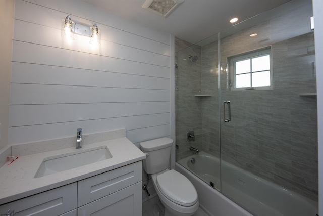 bathroom featuring visible vents, shower / bath combination with glass door, vanity, and toilet