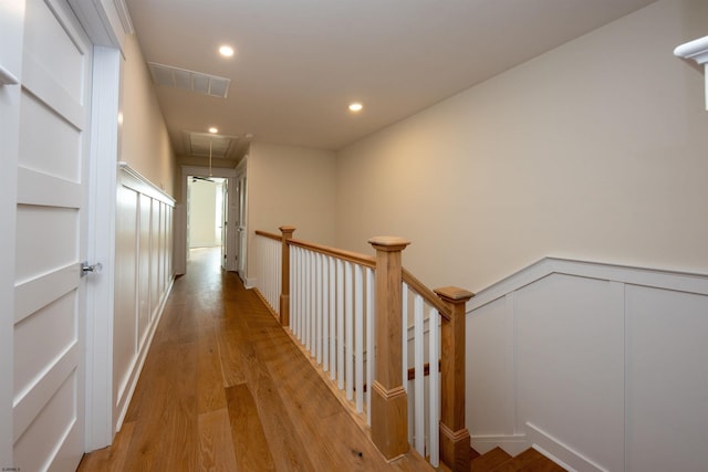 hall featuring light wood-style flooring, recessed lighting, visible vents, an upstairs landing, and attic access