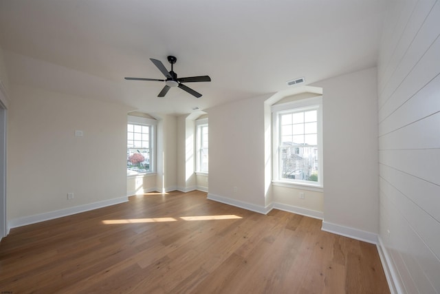 spare room featuring light wood-type flooring, baseboards, visible vents, and ceiling fan