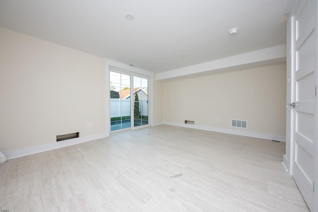 spare room with visible vents, light wood-style flooring, and baseboards