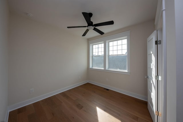 unfurnished bedroom featuring ceiling fan, wood finished floors, visible vents, and baseboards