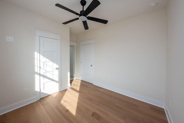 unfurnished room with a ceiling fan, baseboards, and wood finished floors