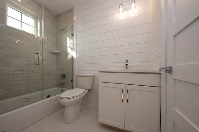 bathroom featuring toilet, tile patterned flooring, bath / shower combo with glass door, and vanity