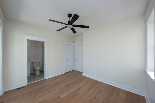 unfurnished bedroom with light wood-type flooring, visible vents, ensuite bath, and baseboards