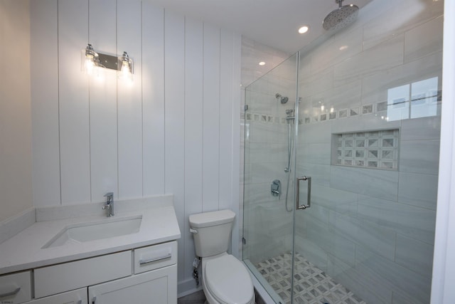 bathroom featuring toilet, a stall shower, and vanity