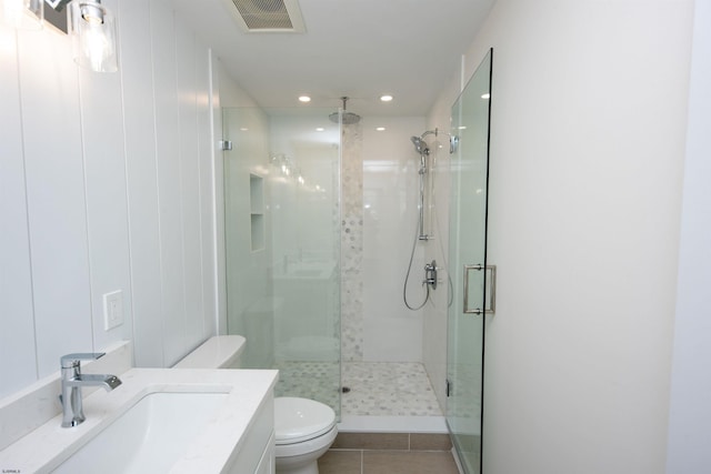 full bathroom featuring visible vents, toilet, a shower stall, vanity, and tile patterned flooring