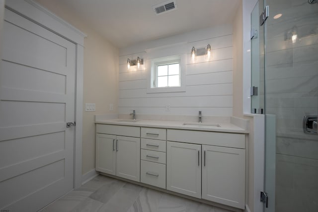 bathroom with marble finish floor, a stall shower, a sink, and visible vents