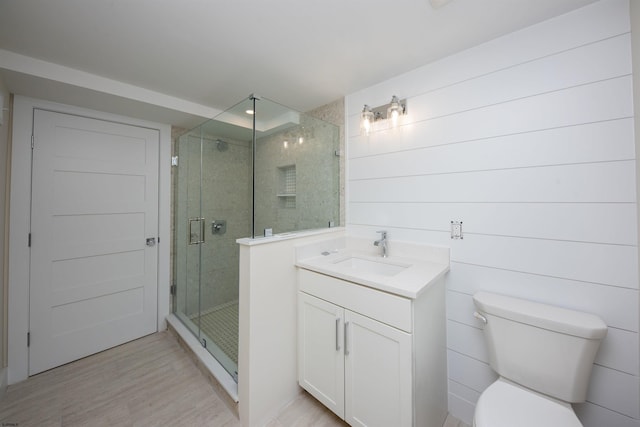 full bath featuring toilet, a stall shower, wood finished floors, and vanity