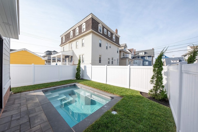 view of swimming pool with a lawn and a fenced backyard