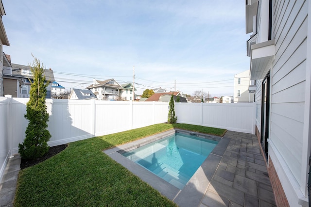 view of pool with a patio, a lawn, and a fenced backyard