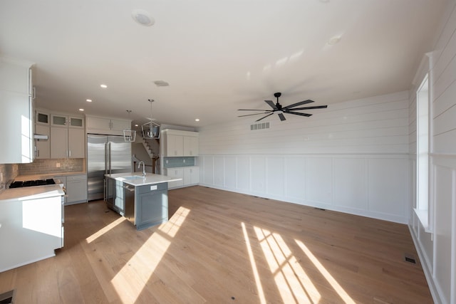 kitchen featuring light countertops, a sink, visible vents, and stainless steel built in fridge