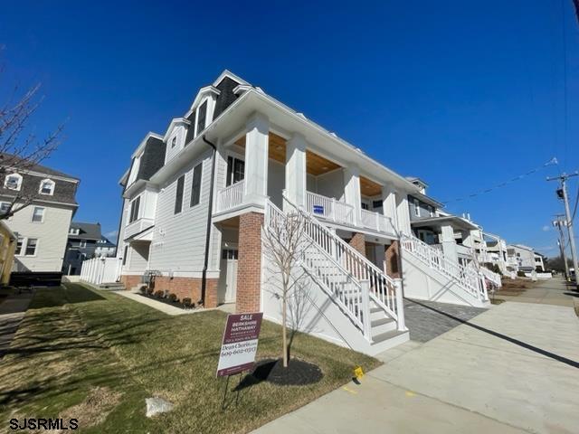 view of front of home featuring stairway and a front lawn