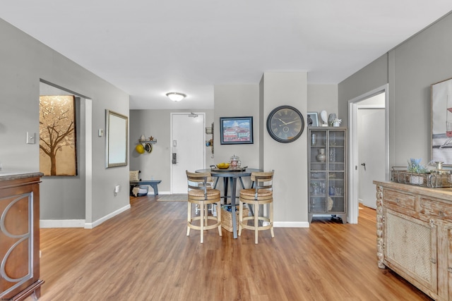 dining area with baseboards and wood finished floors