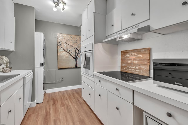 kitchen with white appliances, baseboards, light countertops, light wood-type flooring, and white cabinetry