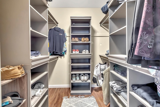 walk in closet with wood finished floors