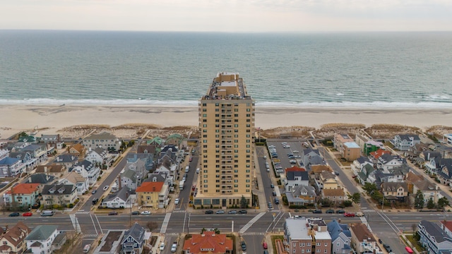 aerial view with a view of the beach, a water view, and a residential view