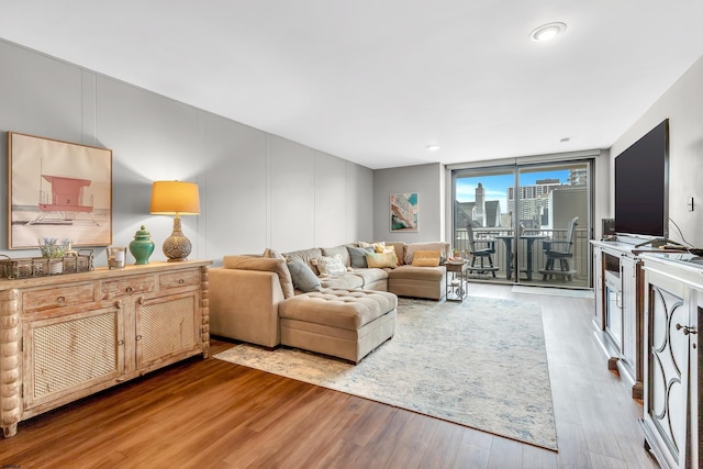 living room with wood finished floors and floor to ceiling windows