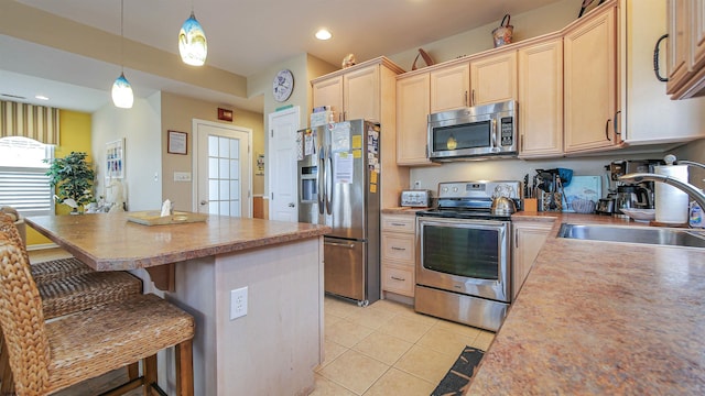 kitchen with a center island, stainless steel appliances, light brown cabinets, a sink, and light tile patterned flooring