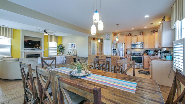 dining room with a tile fireplace, a ceiling fan, and recessed lighting