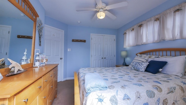 bedroom with a ceiling fan, baseboards, dark colored carpet, and a closet